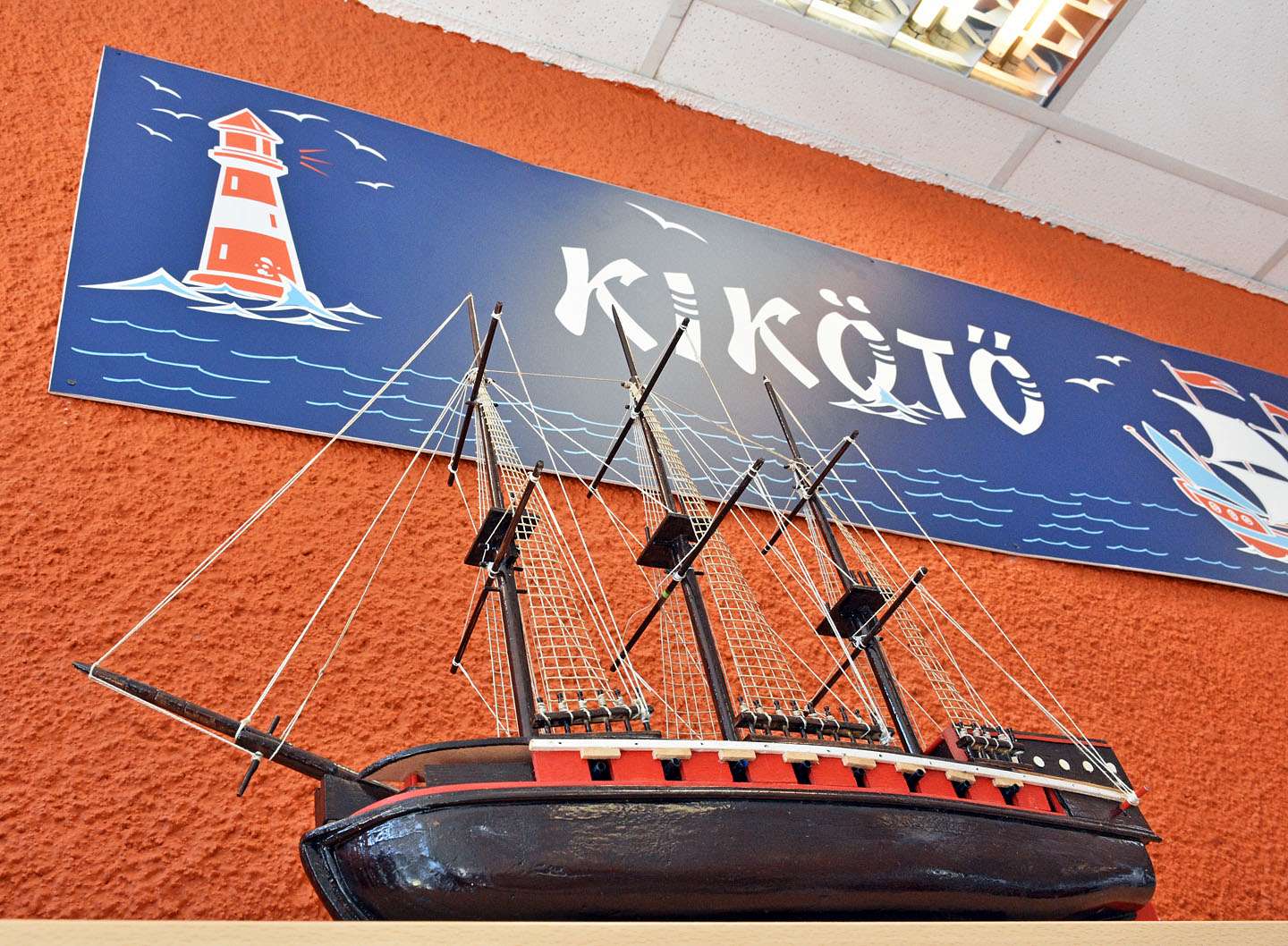 Kikötő felirat egy modellhajóval az előtérben