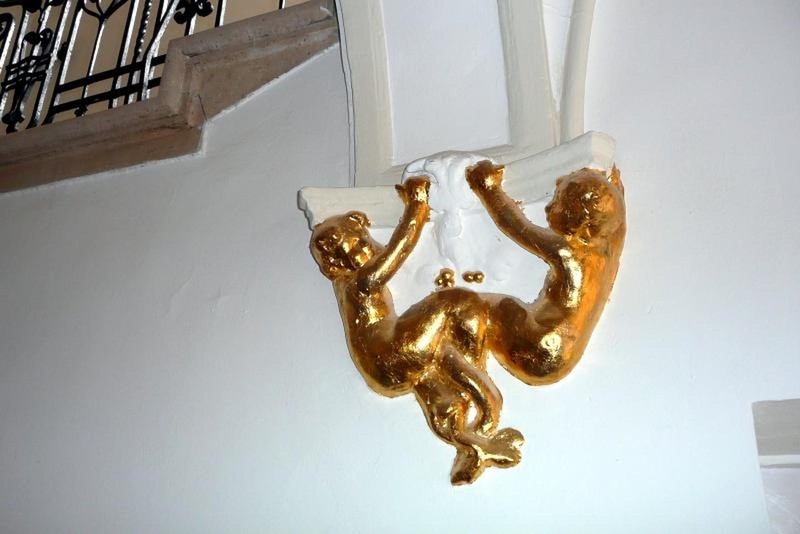 Gold-plated mermaids on the staircase wall