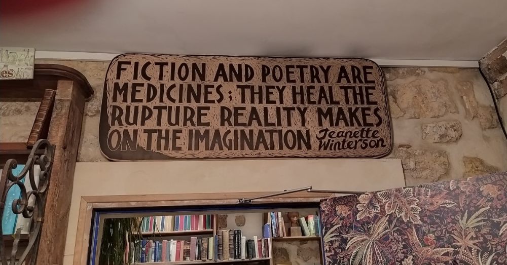 Könyvesbolt falán lévő idézet fotója Fictions an poetry are medicines, they heal the rupture reality makes on the imagination felirattal