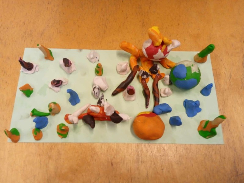 Gyurmafigurák - különös lény, aki a karjában tartja a napot és a földet