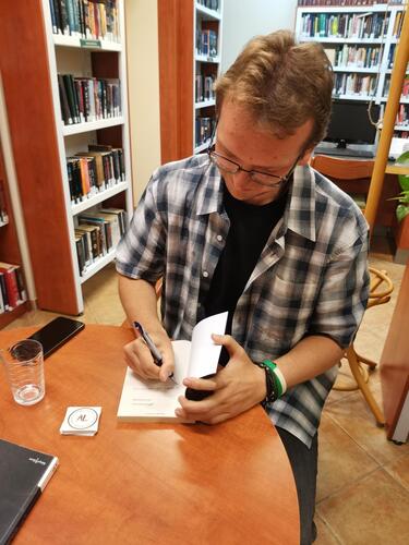 Árvai Levente dedikálja a könyvtár Az útonjáró című példányát