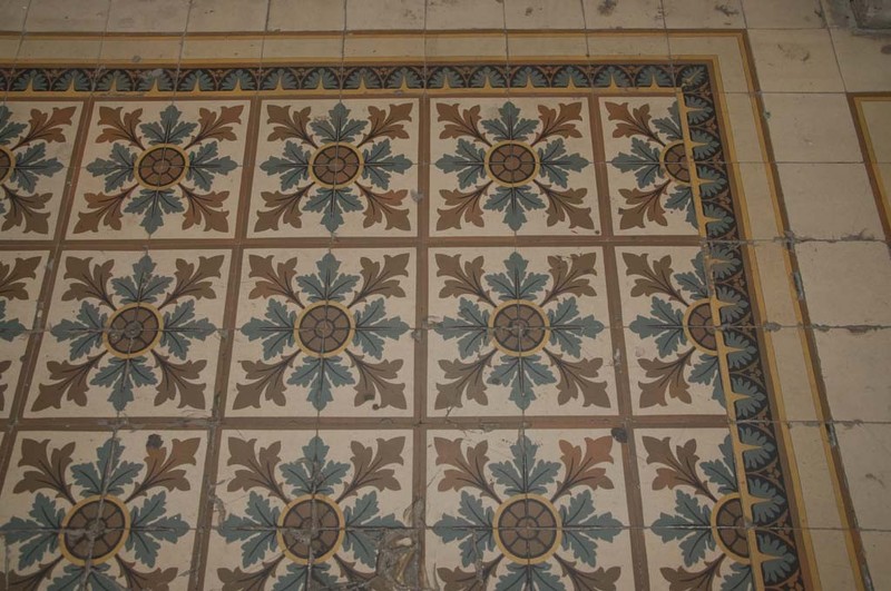 The flower-patterned cement floor tiles in the gateway