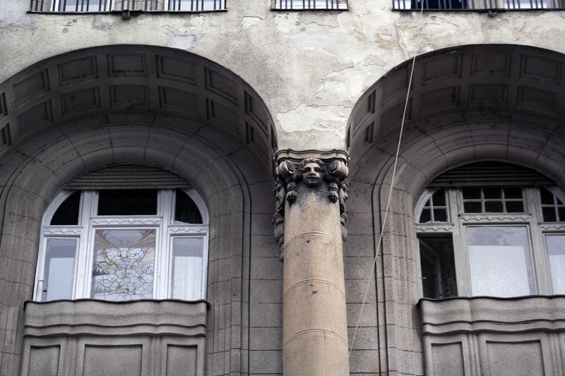 Az épület homlokzata szoborfej oszlopfővel