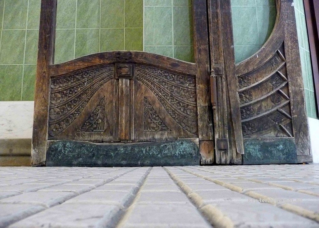 The swinging door and the surviving carvings on the door