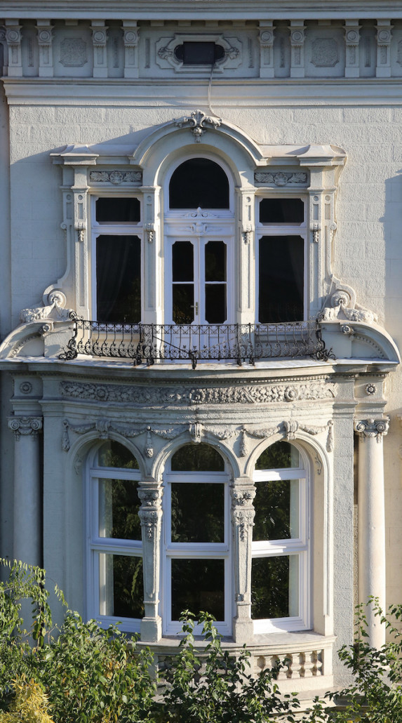 The facade jutting out in a semi-circle with wrought-iron balcony