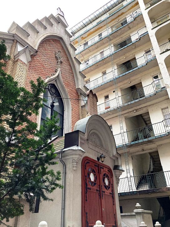 A neogótikus zsinagóga bejárata a bérház udvarán